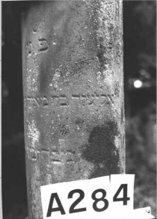 Grabstein 284 (Index: 100082297) Material: Sandstein, weiße Marmorplatte Zustand: leicht verwittert Maße HxBxT: 212x63x57 cm Beschreibung: postamentierte abgebrochene Säule, rechteckige Schriftplatte Symbolik: Kranz um Säule: Grabstein 284A