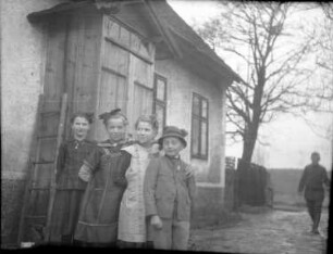 Vier Kinder im Garten eines Hauses. Gruppenaufnahme