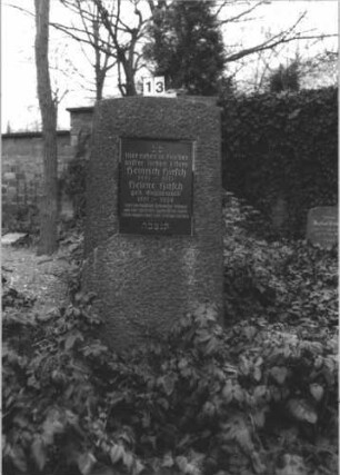 Grabstein 13 (Index: 100106044) Material: Granit, schwarze Marmorplatte Zustand: gut Maße HxBxT: 148x62x22 cm Beschreibung: konische Stele, Sockel, Segmentbogenabschluß, rechteckige Schriftplatte Besonderheit: Doppelgrab für Eheleute: Grabstein 13