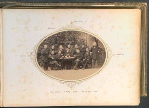 Blatt 5: Gruppenfoto von Herren um einen Tisch vor einem Gebäude