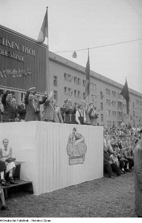 Blick auf die Tribüne mit Erich Uhlich (4.v.r.) und Max Reimann (2.v.r.) auf der Straße der III. Weltfestspiele (heutige Jahnallee)