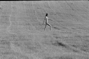 Čičmany. Akt-Pleinair 1980. Abgeerntetes Feld mit einer darüber laufenden jungen Frau