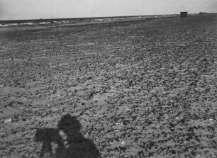 Strand : Blick vom Strand auf das Meer. Im Vordergrund der Schatten des Fotografen.