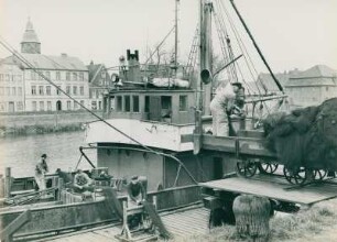 Glückstadt. Fischereihafen. Ein Fischkutter nimmt vor´m Auslaufen Netze an Bord