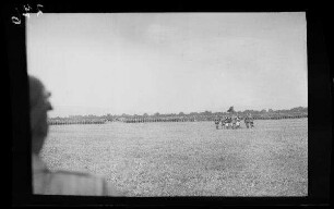 Bei Focșani (Rumänien): Soldatentrupps in breiter Formation auf einem weiten Feld, im Vordergrund Offiziere rund um eine Tatzenkreuz-Standarte ("Kaiserparade")