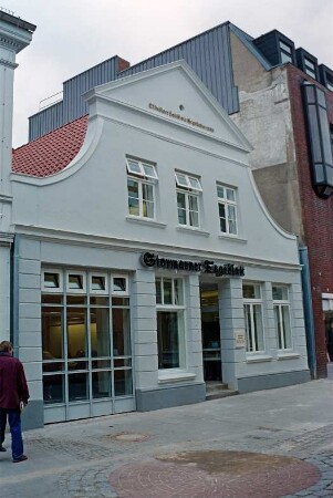 Mühlenstraße 21: giebelständiges Wohn- und Geschäftshaus: nach Sanierung: Straßenfront: Eingang, darüber Firmenschild Stormarner Tageblatt, links bodentiefe Fenster, oben an Giebel Inschrift "Oldesloer Landbote Gegründet 1889": rechts Kaufhaus Nickel [angeschnitten]