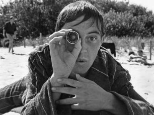 Ein Arbeitskollege des Fotografen an der Deutschen Hochschule für Filmkunst in Potsdam-Babelsberg mit Objektiv an einem Strand