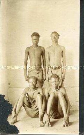 Gruppenbild von vier jungen Männern der Bidjuk und der Biakum vor neutralem Hintergrund